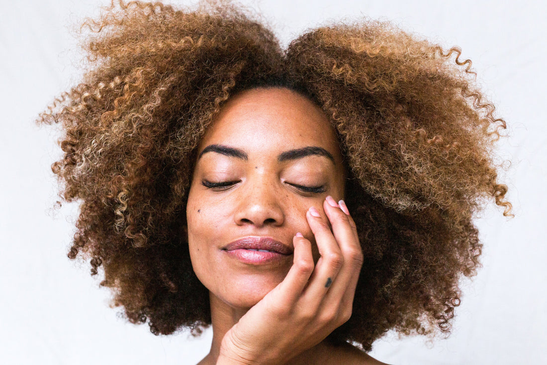 Photo of a woman holding her face representing youthful skin from consuming marine collagen